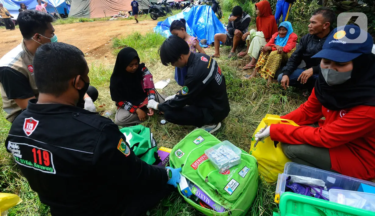 Tenaga medis dari Dinas Kesehatan Kabupaten Karawang melakukan pemeriksaan kesehatan pengungsi korban gempa bumi di desa Mangunkerta, kecamatan Cugenang, Cianjur, Jawa Barat, Rabu (23/11/2022). Hari ketiga pasca gempa magnitudo 5,6 mengguncang Cianjur, sejumlah bantuan dari berbagai kota di Pulau Jawa mulai berdatangan.
(merdeka.com/Arie Basuki)