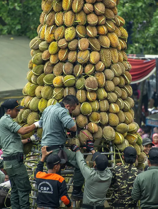 Personel militer bersiap membagikan gunungan durian kepada pengunjung saat festival Kenduren di Jombang, Jawa Timur, Minggu (3/3). Festival Kenduren tersebut merupakan acara tahunan yang digelar setiap memasuki musim panen durian. (Juni Kriswanto/AFP)