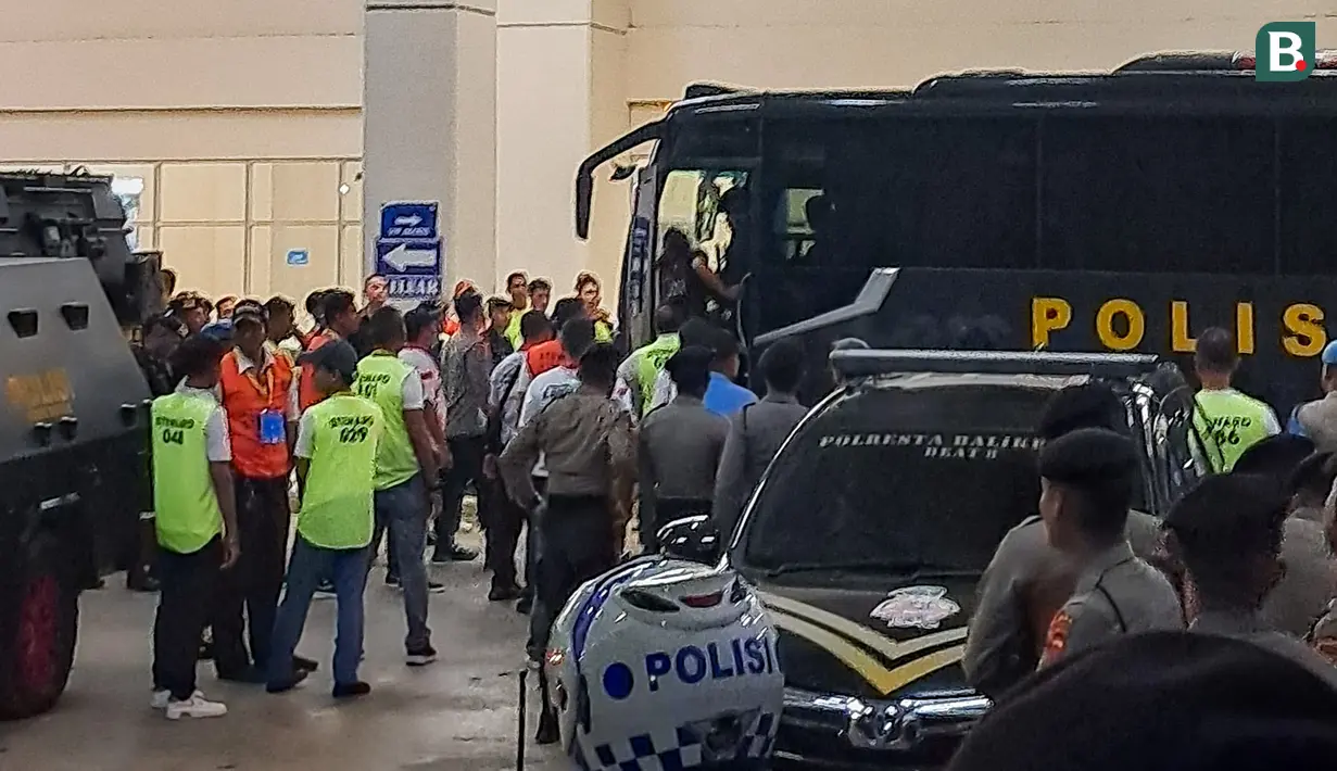 Sejumlah pemain, pelatih, dan ofisial Madura United menaiki bus polisi setelah laga melawan Borneo FC pada laga leg kedua semifinal championship series BRI Liga 1 2023/2024 di Stadion Batakan, Balikpapan, Minggu (19/05/2024). (Bola.com/Muhammad Adiyaksa)