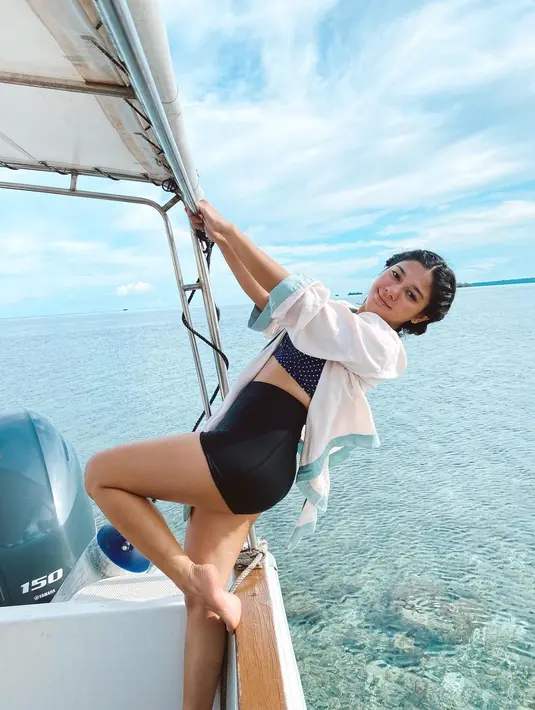 Saat berpose di kapal saja, terlihat hamparan karang yang cantik dengan airnya yang bening. (Foto: Instagram/@naymirdad)