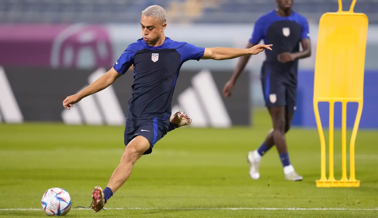 Sergino Dest (kiri) mengikuti sesi latihan resmi di Stadion Al-Gharafa SC, Doha, Senin (28/11/2022). Bek timnas AS ini telah bergabung dengan AC Milan, setelah sebelumnya beraksi di klub Barcelona. (AP Photo/Ashley Landis)