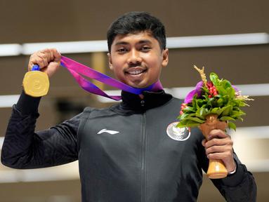 Peraih medali emas Muhammad Sejahtera Dwi Putra dari Indonesia berpose dalam upacara penghargaan cabang olahraga menembak nomor lari 10 meter putra di Fuyang Yinhu Sports Centre pada Asian Games ke-19 di Hangzhou, China, Senin, 25 September 2023. (AP Photo/Aijaz Rahi)