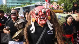 Seorang pria mengenakan topeng saat sosialisasi pawai ogoh-ogoh di kawasan CFD, Bundaran HI, Jakarta, Minggu (19/3). Pawai ogoh-ogoh akan diadakan secara besar di Pura Agung Wira Satya Bhuana, Jakarta, pada Senin (27/3). (Liputan6.com/Angga Yuniar)