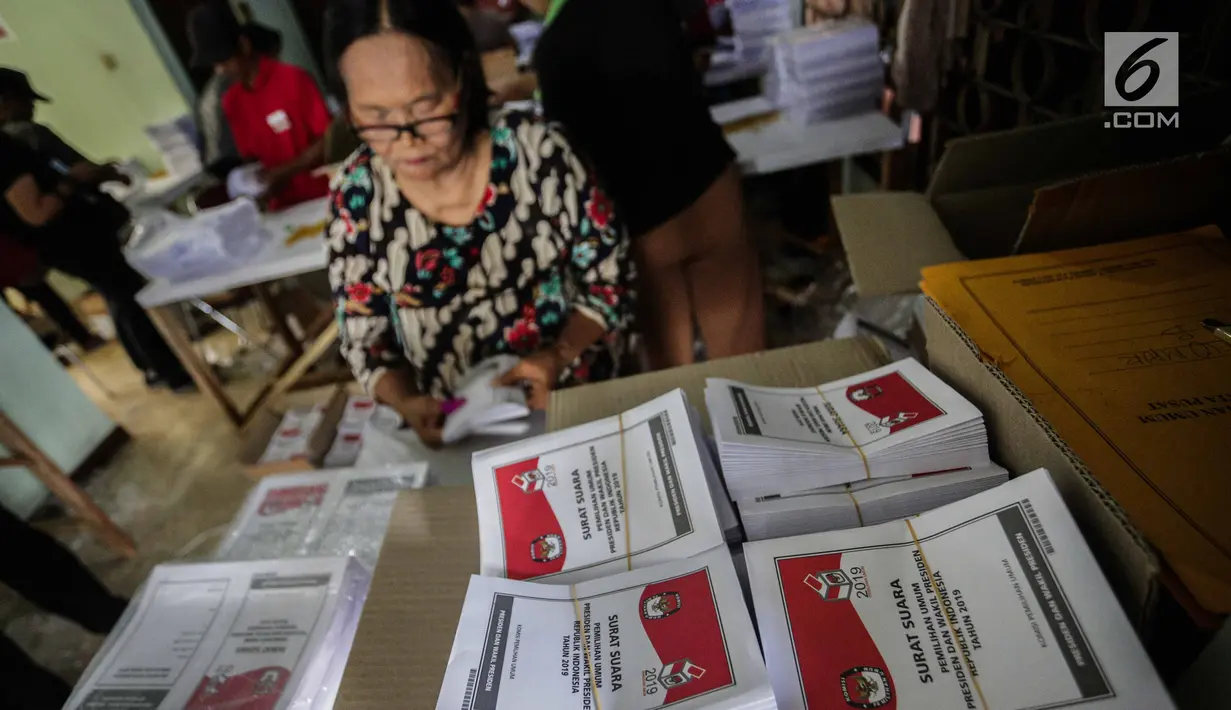 Seorang ibu menyelesaikan pelipatan surat suara Pemilihan Umum 2019 di gudang logistik KPU Jakarta Pusat, Selasa (19/2). Tugas pertama para pekerja ialah menyortir surat suara antara surat suara yang cacat dan yang tidak cacat (Liputan6.com/Faizal Fanani)