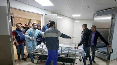 Para jurnalis dan petugas medis tampak membawa jenazah Shiren Abu Akleh, jurnalis Al Jazeera yang tewas tertambak oleh pasukan Israel, ke dalam kamar mayat di salah satu rumah sakit di Jenin, Tepi Barat, pada 11 Maret 2022. (Foto: AP/Majdi Mohammed)