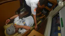 Petugas membantu pemudik menggunakan fasilitas kereta sleeper di Stasiun Gambir, Jakarta, Selasa (12/6). Harga promo tiket kereta kelas luxury  ini sebesar Rp 900 ribu per orang. (Merdeka.com/Imam Buhori)
