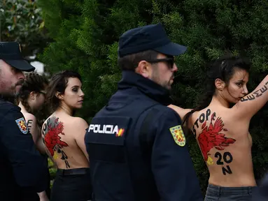 Polisi Spanyol menahan sejumlah aktivis Femen yang melakukan aksi telanjang dada memprotes penggalian makam diktator Spanyol Francisco Franco selama pertemuan tahunan di Madrid, Spanyol (24/11/2019). Aksi ini sekaligus memperingati kematian ke-44 Francisco Franco. (AFP/Oscar Del Pozo)