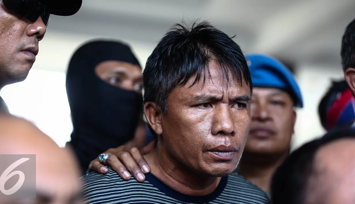 Ridwan Sitorus alias Ius Pane saat tiba di Bandara Halim Perdana Kusumah, Minggu (1/1). Polisi melakukan penangkapan saat Ius tengah berada di salah satu pul bus Antar Lintas Sumatera (ALS). (Liputan6.com/Faizal Fanani)