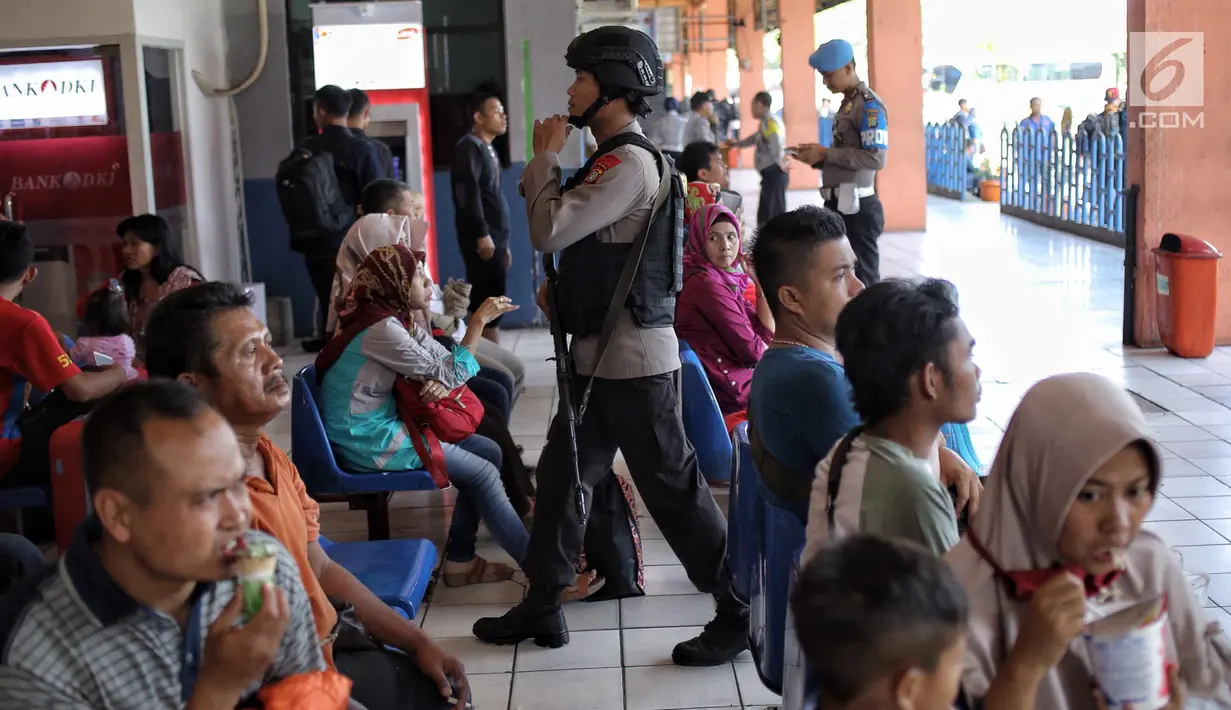 Pasukan Brimob Polda Metro Jaya bersenjata berjalan di antara penumpang di Terminal Kampung Rambutan, Jakarta, Selasa (19/6). Penjagaan dilakukan untuk memberi rasa aman kepada pemudik pada arus balik Lebaran 2018. (Liputan6.com/Faizal Fanani)