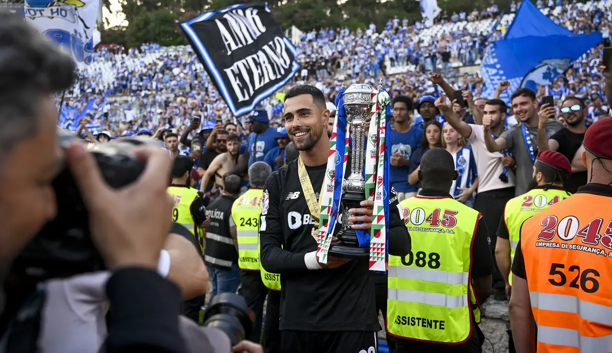 Kiper FC Porto, Diogo Costa memegang trofi Piala Portugal setelah mengalahkan SC Braga pada laga final Piala Portugal 2022/2023 di National Sports Center Jamor Stadium, Oeiras, Portugal (4/6/2023). Pada musim pertamanya, Diogo Costa langsung menjuarai Liga Portugal bersama FC Porto meski hanya tampil dalam 3 laga. Pada musim 2021/2022 ia mulai dipercaya menjadi kiper utama dan mampu merebut trofi kedua Liga Portugal. (AFP/Patricia De Melo Moreira)