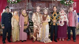 Presiden Jokowi dan Ibu Iriana foto bersama dengan keluarga mempelai pria dan wanita saat menghadiri resepsi pernikahan Novie Ayu Anggraini dan Adrian Anandika Manurung di Lenteng Agung, Jakarta, Jumat (16/2). (Liputan6.com/Pool/Biro Pers Setpres)