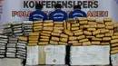 Paket ganja kering dan tiga tersangka diperlihatkan saat rilis kasus di Banda Aceh, Aceh, Kamis (23/5/2019). Satresnarkoba Polresta Banda Aceh mengamankan satu ton paket ganja, tiga tersangka dan satu unit truk tronton saat akan membawa narkotika ke Jakarta. (CHAIDEER MAHYUDDIN/AFP)