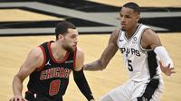 Guard Chicago Bulls, Zach Lavine (kanan) dijaga ketat oleh guard San Antoniu Spurs, Dejounte Murray dalam lanjutan NBA di AT&T Center, Minggu (28/3/2021) pagi WIB. (AP/Darren Abate).