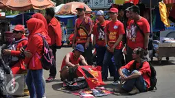 Buruh memilih kaos saat demo memperingati hari lahirnya organisasi buruh internasional World Federation of Trade Unions (WFTU) di Jakarta (3/10/2015).  Sejumlah PKL memanfaatkan demo buruh untuk meraup sedikit keuntungan. (Liputan6.com/Gempur M Surya)