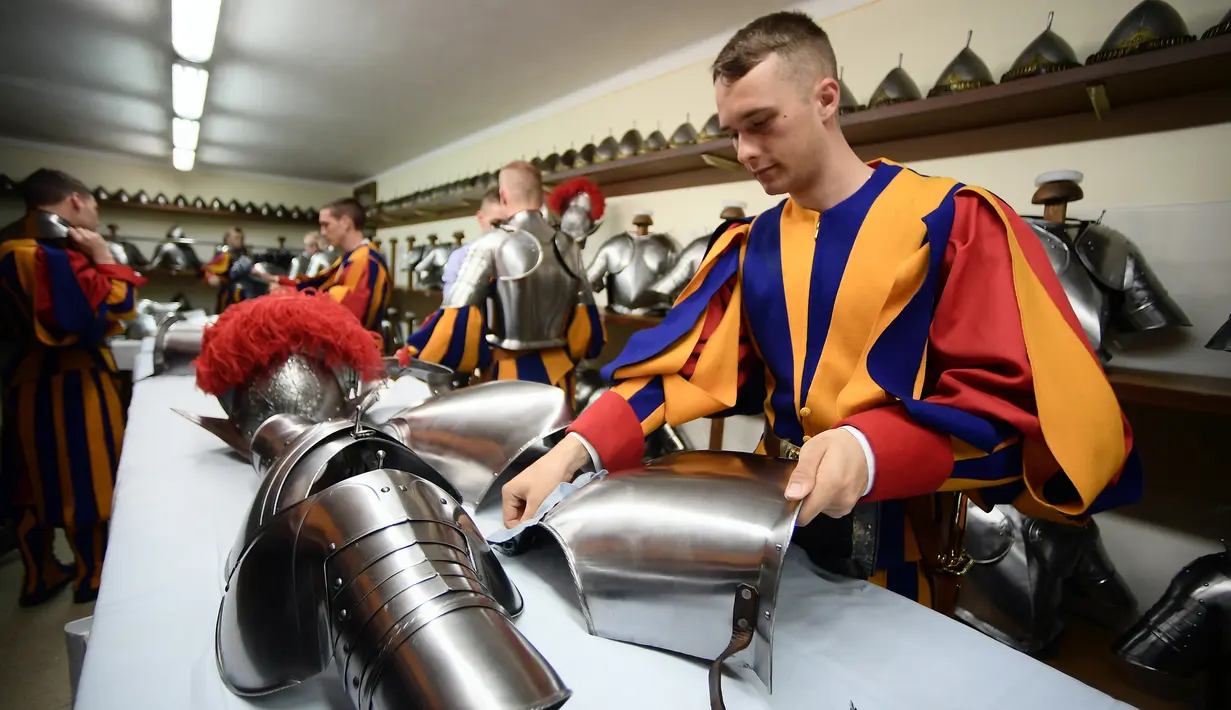 Seorang Pasukan Pengawal Swiss menyiapkan baju besinya untuk menghadiri upacara tahunan di Kota Vatikan (6/5). Oleh Vatikan, Swiss Guard ditugaskan mengawal Paus (kepala negara) dan pembantu-pembantunya yang setingkat menteri. (AFP/Filippo Monteforte)