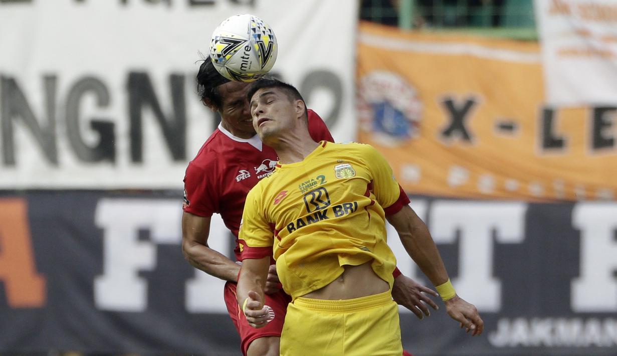 Striker Bhayangkara FC, Ramiro Fergonzi, berebut bola atas dengan Bek Persija Jakarta, Ryuji Utomo, pada laga Shopee Liga 1 di Stadion Patriot Chandrabhaga, Bekasi, Sabtu (10/8). Persija bermain imbang 1-1 atas Bhayangkara. (Bola.com/Yoppy Renato)