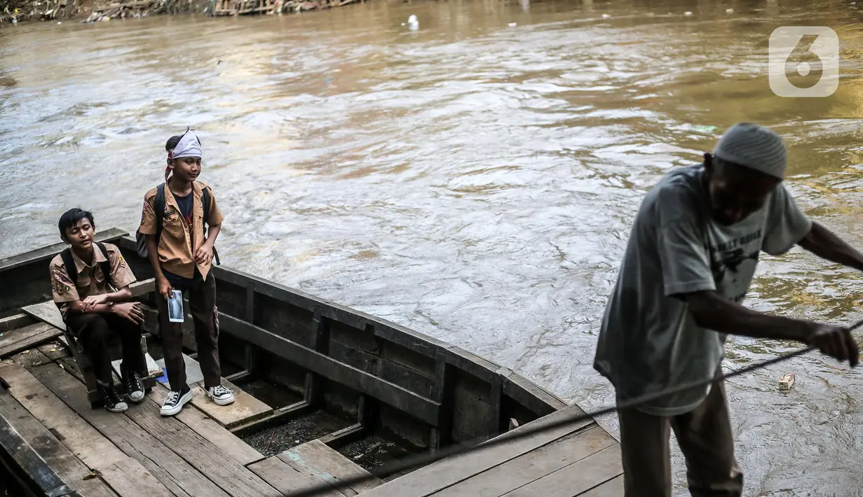 Pelajar menaiki perahu eretan di kawasan bantaran Kali Ciliwung, Jakarta, Rabu(16/11/2022). Pemerintah Provinsi DKI Jakarta akan melakukan normalisasi Kali Ciliwung sepanjang 4,8 kilometer di empat lokasi prioritas yakni Kelurahan Rawajati Cawang, Cililitan, dan Kampung Melayu dengan rancangan anggaran APBD 2023 sebesar Rp469 miliar. (Liputan6.com/Faizal Fanani)