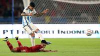 Pemain Timnas Indonesia, Marselino Ferdinan (bawah) terjatuh ketika berebut dengan pemain Argentina, Cristian Romero pada laga FIFA Matchday di Stadion Utama Gelora Bung Karno (SUGBK), Senayan, Jakarta, Senin (19/06/2023). (Bola.com/Bagaskara Lazuardi)