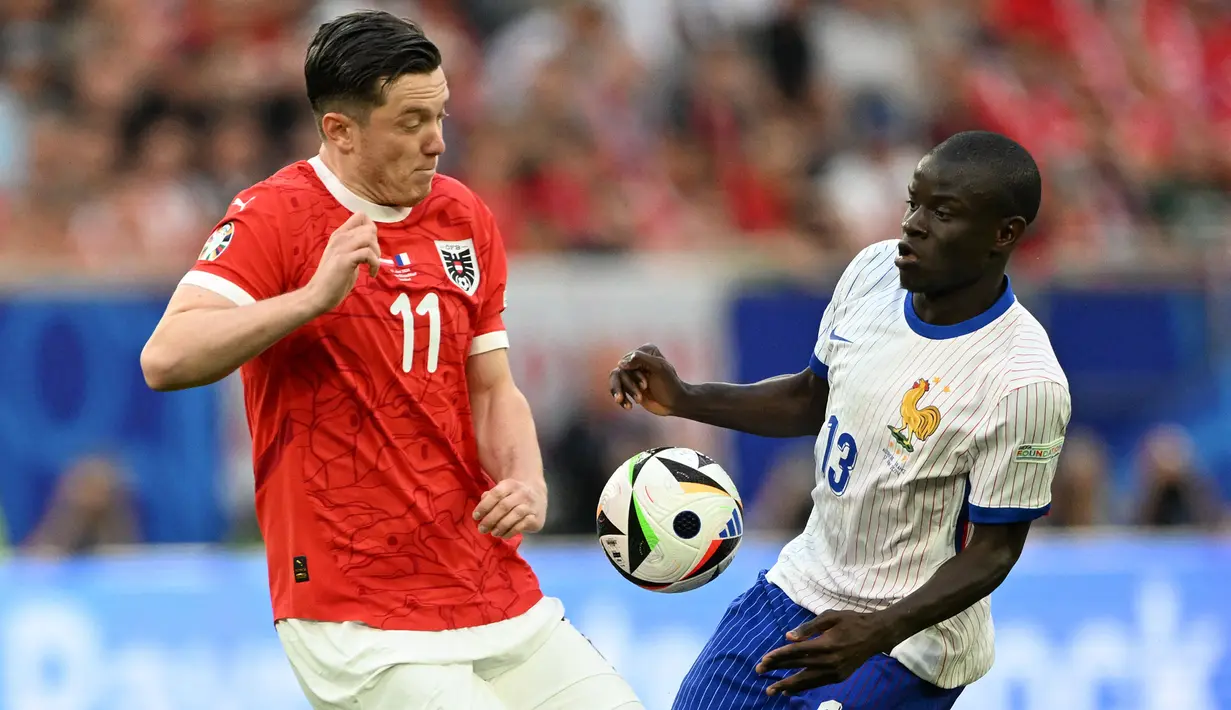 Pemain Prancis, N'Golo Kante (kanan) berebut bola dengan pemain Austria, Michael Gregoritsch pada laga Grup D Euro 2024 di Duesseldorf Arena, Duesseldorf, Jerman, Selasa (18/06/2024) WIB. (AFP/Patricia De Melo Moreira)
