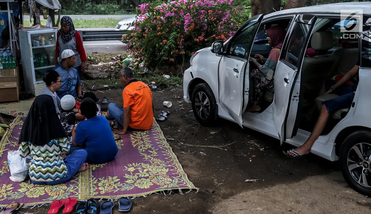 Sejumlah pemudik menggelar tikar beristirahat di rest area Tol Timur - Palimanan - Kanci,  Cirebon, Jawa Barat, Sabtu (1/7). Mereka memanfaatkan rest area untuk beristirahat sebelum meneneruskan perjalanan kembali ke Jakarta. (Liputan6.com/Faizal Fanani)