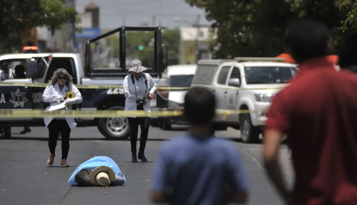 Mayat jurnalis senior Meksiko, Javier Valdez, tergeletak di jalan setelah tewas ditembak di ibu kota negara bagian, Culiacan, Senin (15/5). Valdez dicegat kelompok bersenjata saat mengemudikan mobil sekitar satu blok dari kantornya. (FERNANDO BRITO/AFP)