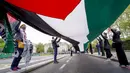 <p>Orang-orang memegang bendera Palestina saat mereka berbaris dalam solidaritas untuk rakyat Palestina di tengah konflik yang sedang berlangsung dengan Israel selama demonstrasi di London, Inggris, Sabtu (15/5/2021). (AP Photo/Alberto Pezzali)</p>