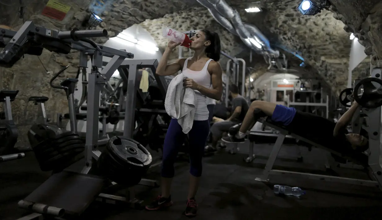 Anoush Belian beristirahat saat sesi latihan di tempat gym, Yerusalem (20/8/2015). Belian merupakan binaragawati pertama Palestina yang akan mengikuti kompetisi di Israel. (REUTERS/Ammar Awad)