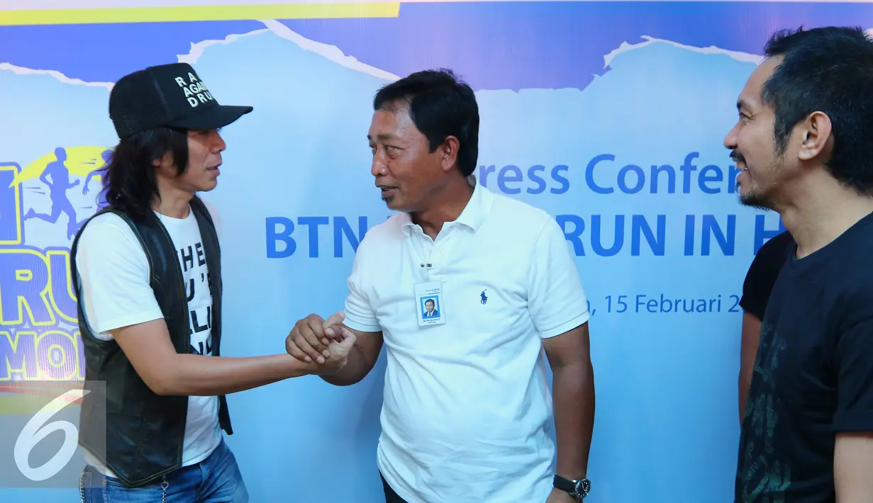 Direktur Bank BTN Sis Apik Wijayanto (tengah) berjabat tangan dengan Bimbim Slank usai jumpa pers BTN di markas Slank, Jakarta, Senin (15/02/2016). BTN menggelar Homerun in Harmony bersama Slank untuk merayakan HUT ke-60 (Liputan6.com/Herman Zakharia)