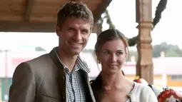 Penyerang Bayern Munchen, Thomas Mueller berpose bersama istrinya, Lisa saat menghadiri Festival Oktoberfest di Munich, Jerman, (2/9). (REUTERS/Alexander Hassenstein)
