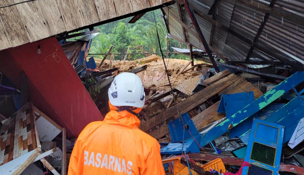Foto selebaran yang diambil dan dirilis pada 7 Maret 2023 oleh kantor Kementerian Komunikasi dan Informatika Natuna ini menunjukkan tim penyelamat sedang memeriksa kerusakan akibat tanah longsor di Natuna, Kepulauan Riau (Kepri).  Kapolres Natuna Ajun Komisaris Besar Nanang Budi Santosa mengatakan, saat ini masih ada sekitar 47 orang dinyatakan hilang dan 27 rumah tertimbun material tanah longsor. (HO / Natuna ministry of communication / AFP)