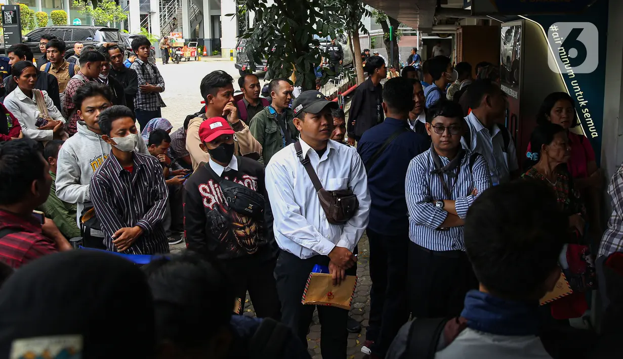 Ratusan warga menunggu panggilan untuk menyerahkan surat lamaran sebagai petugas Penanganan Prasarana dan Sarana Umum (PPSU) di halaman Loket Penerimaan Surat dan Barang, Balai Kota Jakarta, Selasa (22/4/2025). (Liputan6.com/Angga Yuniar)