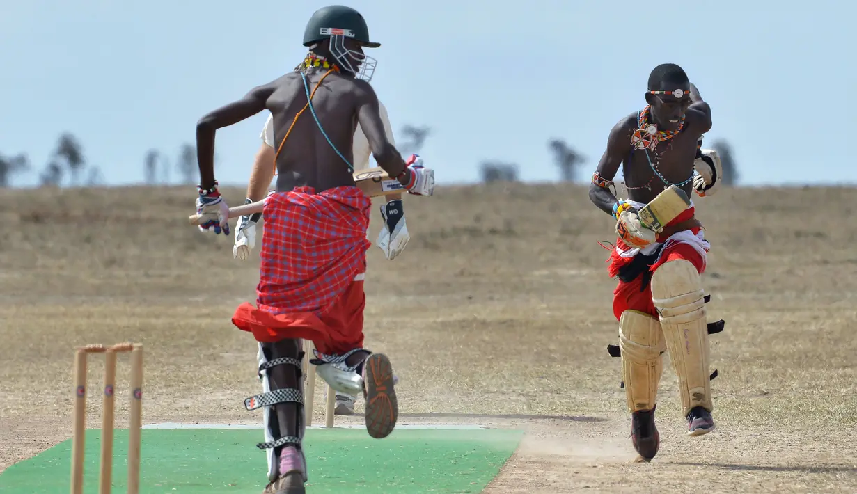 Pria dari suku Maasai berlari saat pertandingan amal kriket di kaki Gunung Kenya (18/6). Karena minat penduduk Kenya terhadap olahraga kriket tinggi, akhirnya olahraga ini digunakan untuk kampanye sosial dan lingkungan hidup. (AFP Phoo/Tony Karumba)