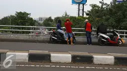 Sejumlah remaja berkumpul di atas jalan layang Pasar Rebo, Jakarta, Sabtu (14/1). Menurut warga sekitar, bahwa tempat tersebut memang kerap dijadikan arena nongkrong muda-mudi. (Liputan6.com/Immanuel Antonius)