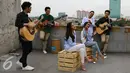 Suasana pembuatan video klip soundtrack 'Cek Toko Sebelah' di kawasan Cempaka Putih, Jakarta, Selasa (29/11). The Overtunes dan Grup Vocal GAC berkolaborasi dalam pembuatan video tersebut. (Liputan6.com/Herman Zakharia)