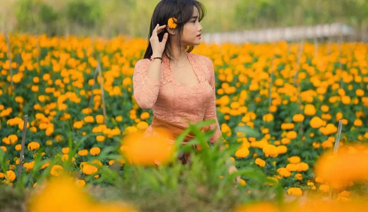 Fuji baru saja mengunggah potret dirinya di tengah ladang bunga warna orange yang indah. Bunga tersebut senada dengan warna kebaya yang ia kenakan. [@fuji_an]