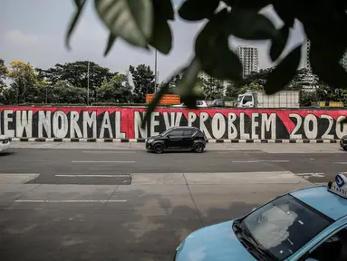 Pengendara melintasi mural bertema tatanan normal baru atau 'New Normal' di kawasan Tanjung Barat, Jakarta, Selasa (9/6/2020). Mural itu pesan menyambut era new normal ketika setiap orang harus mengedepankan protokol kesehatan saat berkegiatan di tengah pandemi COVID-19. (Liputan6.com/Faizal Fanani)
