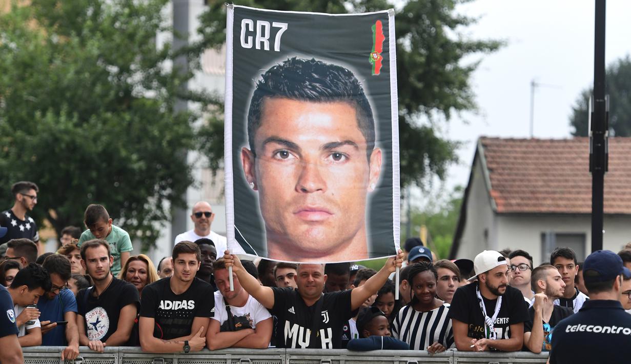 Para suporter menyambut kedatangan bintang baru Juventus, Cristiano Ronaldo, saat tiba untuk menjalani tes kesehatan di area Stadion Allianz, Turin, Senin (17/7/2018). CR 7 hijrah dari Real Madrid ke Juventus. (AFP/Miguel Medina)