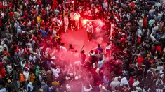 Para pendukung Maroko merayakan kemenangan negaranya atas Portugal pada babak 8 besar Piala Dunia 2022, di ibu kota Rabat, Sabtu (10/12/2022). Maroko mengubur mimpi Cristiano Ronaldo lewat gol semata wayang yang diciptakan Youssef En-Nesyri di babak pertama. (FADEL SENNA / AFP)