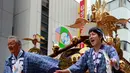 Peserta berdiri diatas kuil portabel yang diarak saat perayaan Festival Kanda Matsuri di Tokyo, Minggu (14/5). Kanda Matsuri merupakan sebuah festival yang berpusat di kuil Kanda Myojin, dan diadakan pada akhir pekan. (AP Photo / Shizuo Kambayashi)