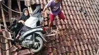 Dua remaja bersama sepeda motor yang mereka gunakan terjebak dipuing puing genteng rumah, sementara satu remaja putri lainya berada dibawah rumah warga, genteng rumah nampak hancur berantakan. (Liputan6.com/Jayadi Supriadin)