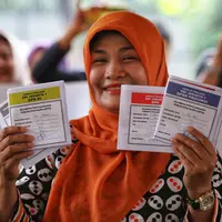 Warga menunjukkan contoh surat suara saat simulasi pemungutan dan pencoblosan surat suara Pemilu 2019 di Taman Suropati, Jakarta, Rabu (10/4). Simulasi pemungutan surat suara dilakukan untuk meminimalisir kesalahan dan kekurangan saat pencoblosan pemilu pada 17 April nanti (Liputan6.com/Johan Tallo)