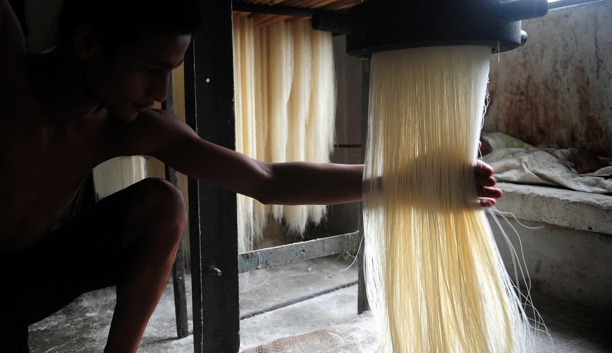 Seorang pekerja sedang membuat bihun saat proses pembuatan Sheerkhorma di Allahabad, India, 16 Juni 2016. Sheerkhorma merupakan hidangan manis tradisional khas Ramadan bagi muslim di India. (AFP PHOTO/SANJAY Kanojia)