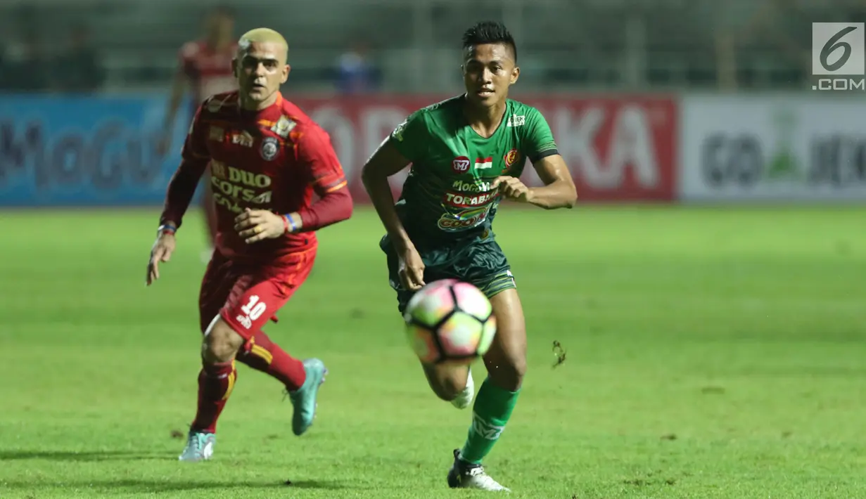 Bek PS TNI, Ganjar Mukti (kanan) berebut bola dengan pemain depan Arema FC, Cristian Gonzales dilanjutan Liga 1 Indonesia di Stadion Pakansari, Bogor, Senin (3/7). Laga kedua tim berakhir imbang 0-0. (Liputan6.com/Helmi Fithriansyah)