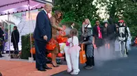 Presiden AS, Donald Trump dan Ibu Negara, Melania Trump membagikan permen kepada anak-anak saat open house perayaan pesta Halloween di Gedung Putih, Senin (30/10). Para siswa dan orang tua dari 20 sekolah hadir di acara ini. (AP/Pablo Martinez Monsivais)