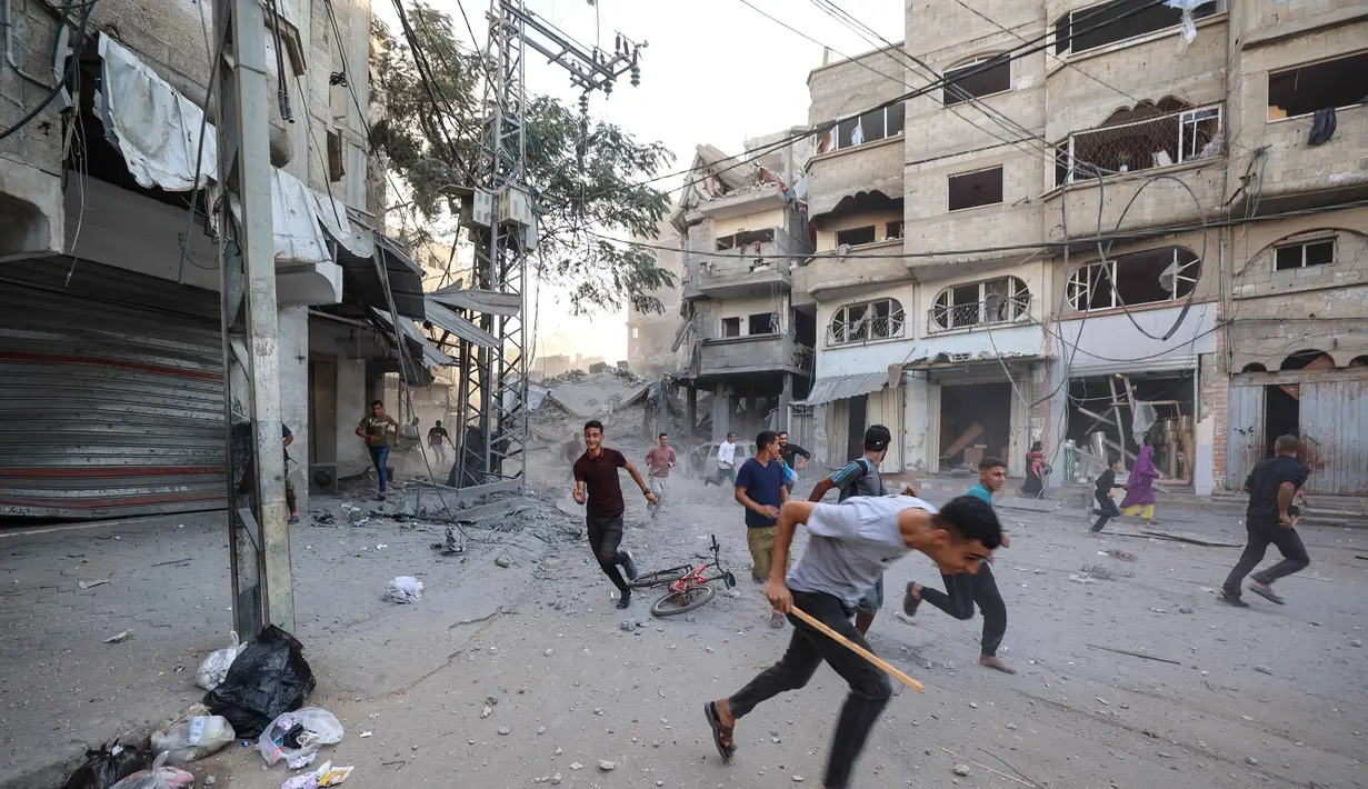 Orang-orang berlari mencari perlindungan setelah serangan Israel yang menargetkan sebuah bangunan di kamp pengungsi Palestina Bureij di Jalur Gaza tengah pada 19 Oktober 2025. (Eyad BABA/AFP)