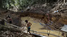 Suku Yanomami indian melihat kondisi hutan yang rusak akibat pertambangan emas ilegal di jantung Hutan Amazon, Roraima, Brasil, pada 18 April 2016. Padahal tempat ini menjadi rumah bagi ribuan orang suku Yanomami. ( REUTERS / Bruno Kelly) 