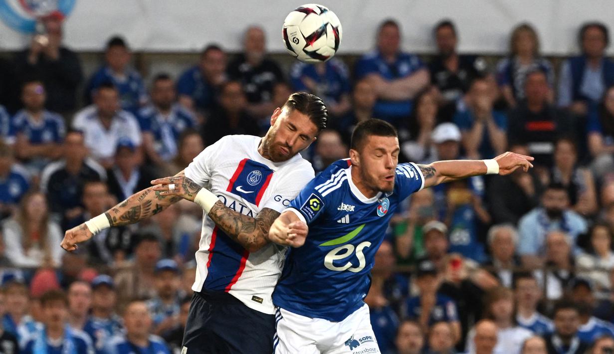 Bek PSG, Sergio Ramos (kiri) berduel udara dengan bek Strasbourg, Frederic Guilbert pada laga pekan ke-37 Liga Prancis 2022/2023 di Stade de la Meinau, Strasbourg, Prancis (27/5/2023). (AFP/Patrick Hertzog)