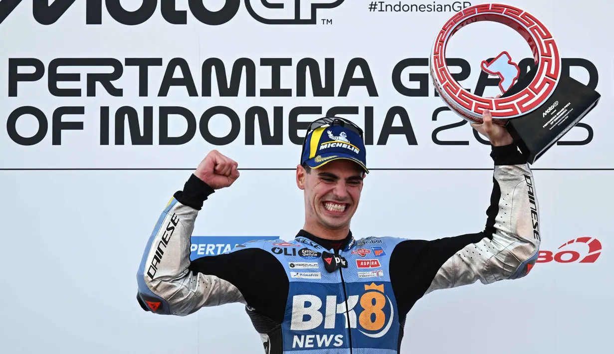 Pembalap tim BK8 Gresini Racing MotoGP asal Spanyol, Fermin Aldeguer merayakan kemenangan di podium usai menjuarai Grand Prix MotoGP Indonesia 2025 di Sirkuit Internasional Mandalika, Nusa Tenggara Barat, Minggu 5 Oktober 2025. (SONNY TUMBELAKA/AFP)