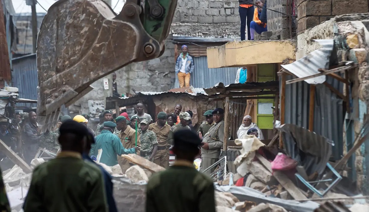 Petugas penyelamat menyisir puing bangunan lima lantai yang runtuh di daerah permukiman di ibu kota Kenya, Nairobi, Minggu (4/6). Diperkirakan puluhan orang masih belum ditemukan lantaran masih terjebak di antara reruntuhan. (AP Photo/Ben Curtis)