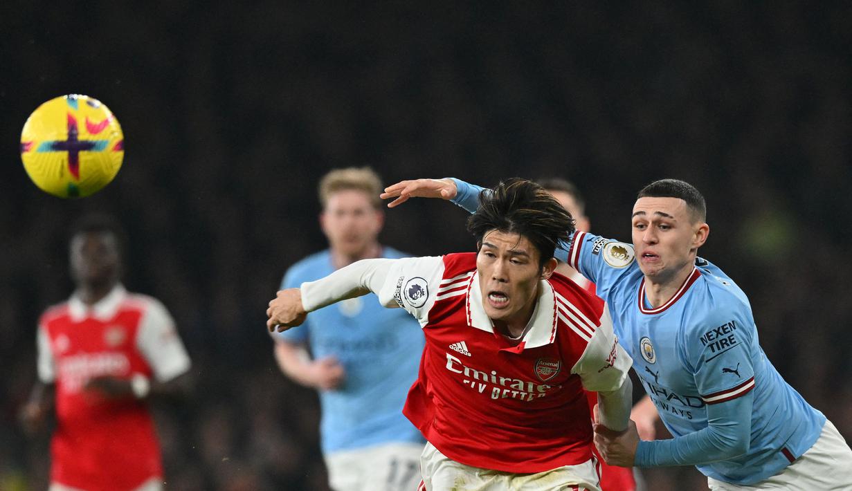 Pesepak bola asal Jepang, Takehiro Tomiyasu (kiri) saat ini tengah menjalani musim ketiga bersama Arsenal sejak didatangkan dari Bologna pada awal musim 2021/2022 dengan nilai transfer 18,6 juta euro. Hingga kini ia telah bermain dalam 44 laga bersama The Gunners di Premier League dengan raihan 4 assist. (AFP/Glyn Kirk)